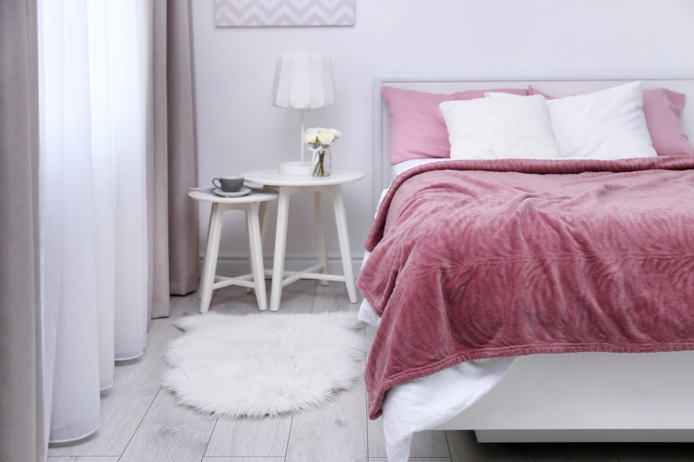 Tela rosa sobre cama y parez gris