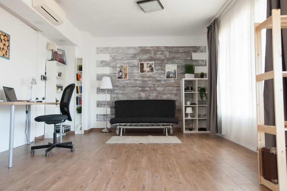 Habitación con paredes en color gris y blanco y suelo de madera